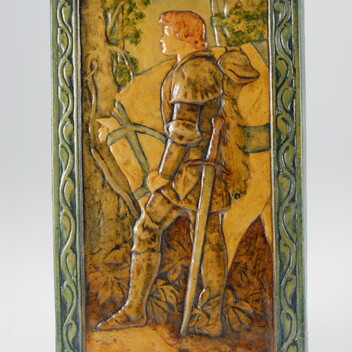 Yellow toned ceramic plaque with a knight and horse