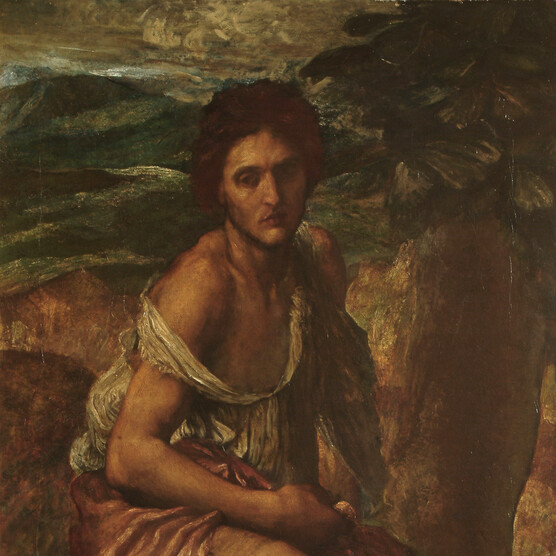 A man in rags sits in a rocky landscape