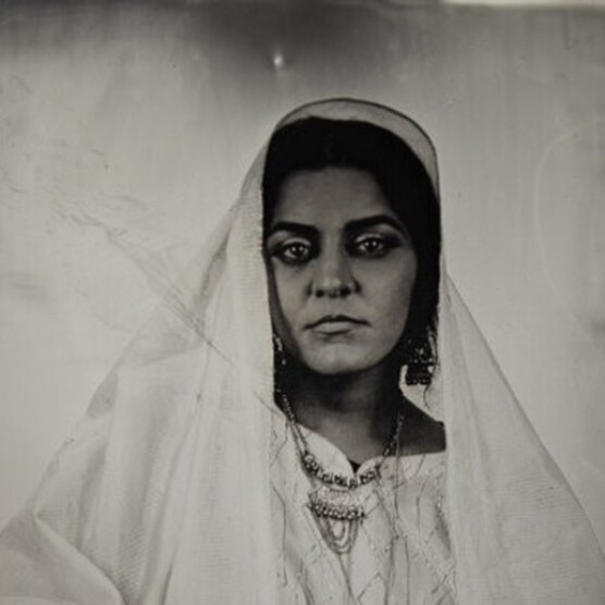 A dark Tintype photograph of a woman