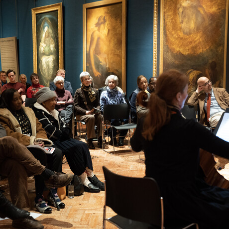 A photograph of an audience sitting in the Historic Galleries watching The Atchison Quartet play the violin