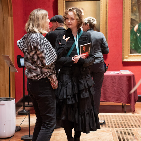 A photograph of two women standing chatting in the historic galleries