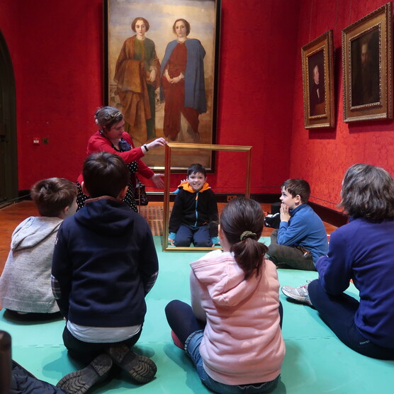 A group of families sit in the gallery listening to stories