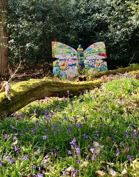 A photograph of a large man made butterfly installation in the woods of Watts Gallery