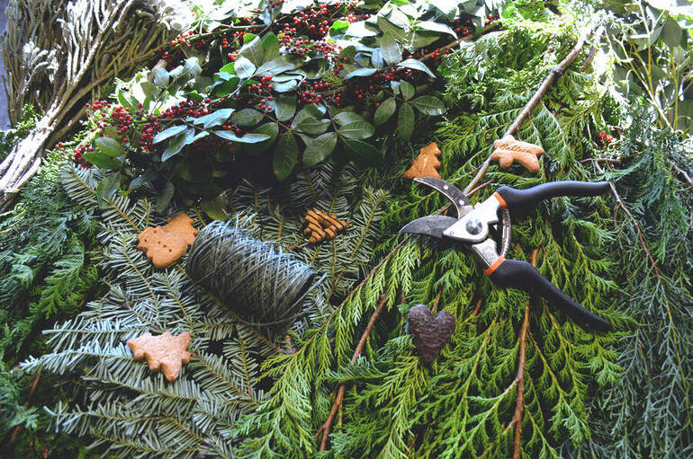A collection of fir tree branches, string, Christmas ornaments and secateurs
