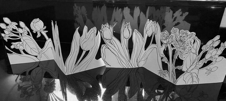 A photograph of drawings of flowers cut out of paper