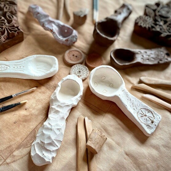 A photograph of a selection of ceramics laid out on a table with tools