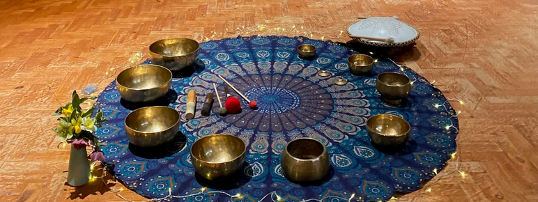 A set up on the floor in the historic galleries of a rug, candles and lights