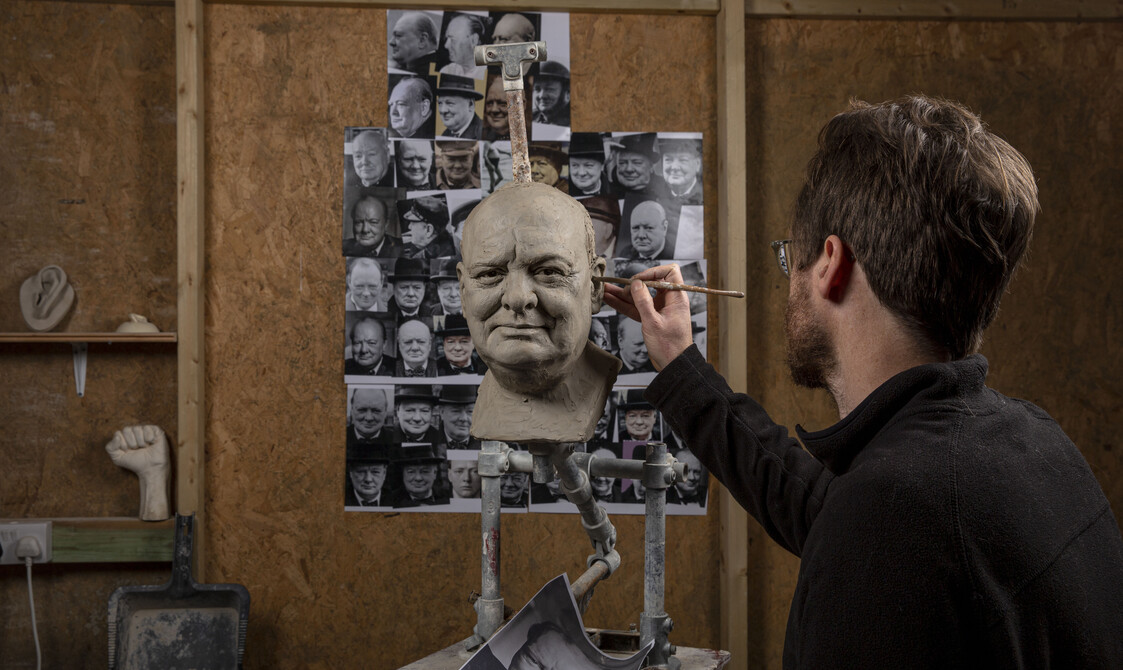 Jethro Crabb working on a clay sculpture of Churchill in his studio.