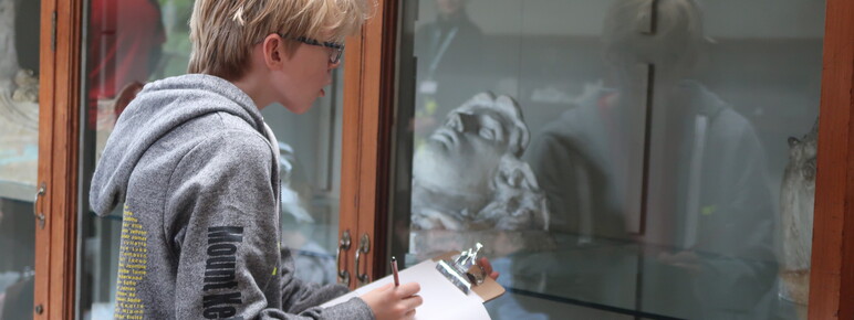 A blonde boy looks into the glass cabinet in the Sculpture Gallery
