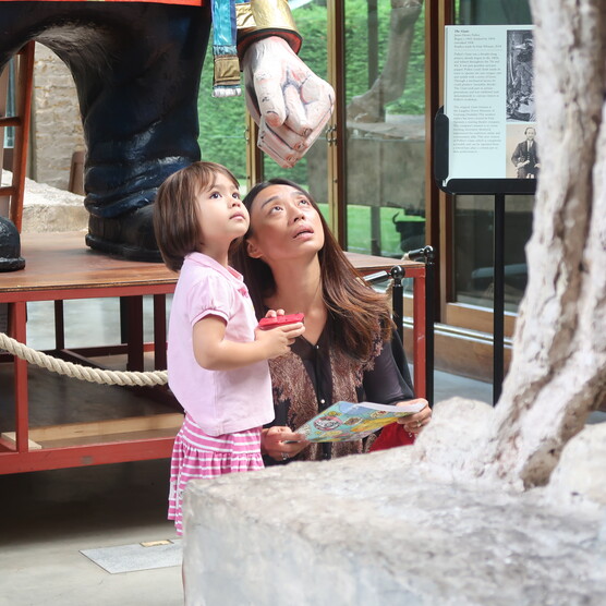 A women and her daughter look up at Tennyson in the Sculpture Gallery