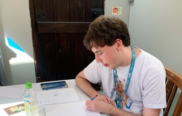 Sam draws in a sketchbook