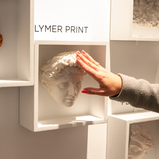 A woman puts her hand on a mould of Clytie in A Fragmented Legacy