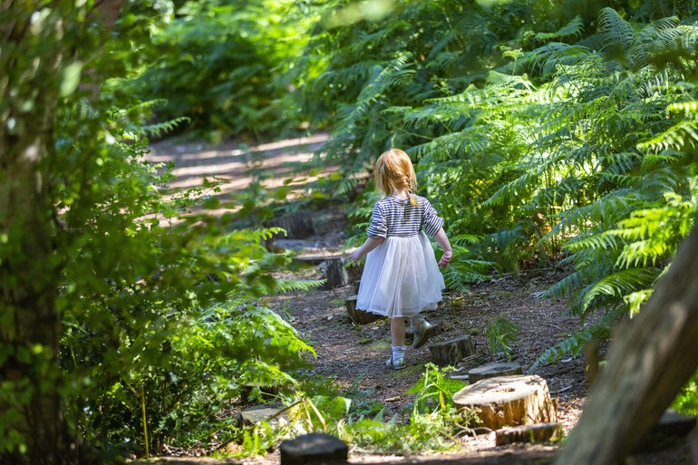 Photo of a young child walking along some tree sump stepping stones in the Verey Playwood