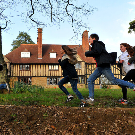 A group of children run in front of Limnerslease