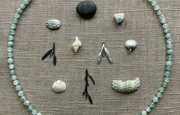 Photo of a selection of necklace charms with a beaded necklace