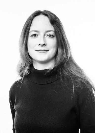 Black and white photo of Louise Hopkins, an adult woman with long dark hair wearing a black top