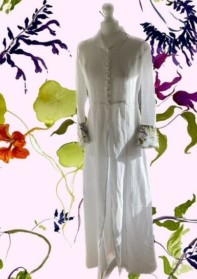 Image of a long white dress placed on a mannequin with a digitally produced floral background