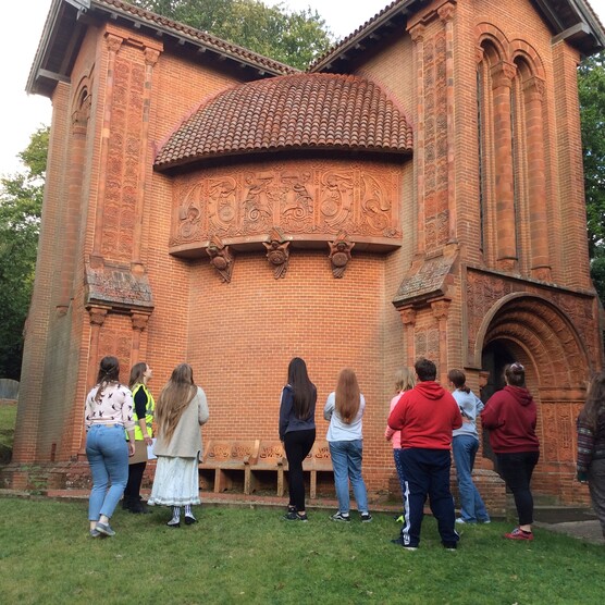 Group of young people outside terracotta chapel