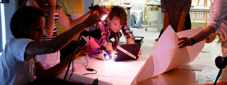 A group of teenagers experiment with lights whilst taking photos