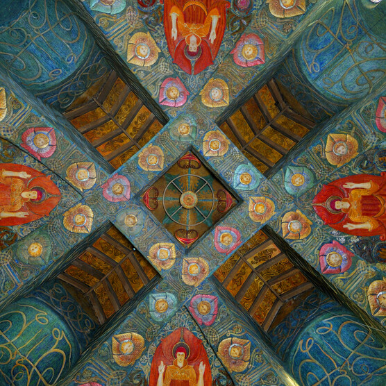 Looking up at the colourful highly-decorated chapel ceiling. It features blue turquoise panels and four red angels.