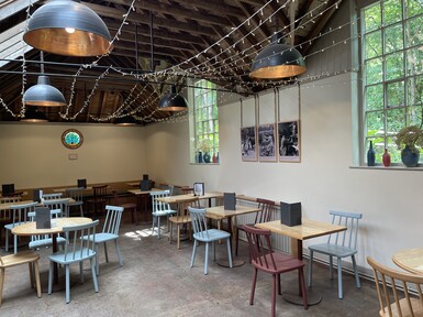 The inside of the tea shop is beige with a wooden beam ceiling. There are wooden chairs and windows.