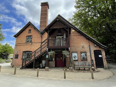 The visitor centre is a red brick building with an arched roof. There is a staircase along the side to allow access to a second story entrance