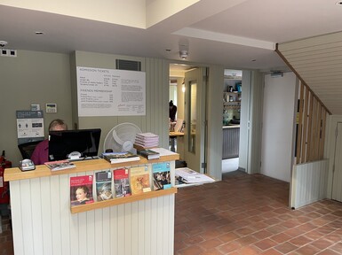 Visitor desk with leaflets and staff member on computer