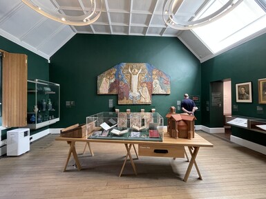 Gallery with works on table and wall