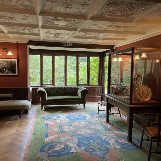 Living room with decorated ceiling, sofa and display case
