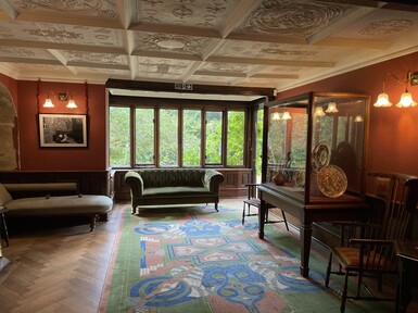 Living room with decorated ceiling, sofa and display case