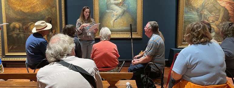 Community programme curator Kate Rockhold gives a talk to a group in front of G F Watts's painting Hope
