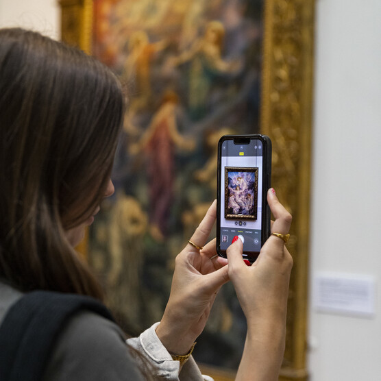 Women takes photo in De Morgan Gallery