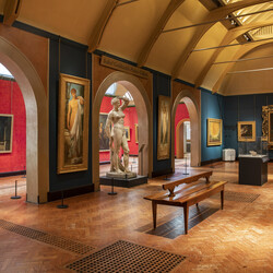 Historic gallery features oil paintings in gold frames and sculptures