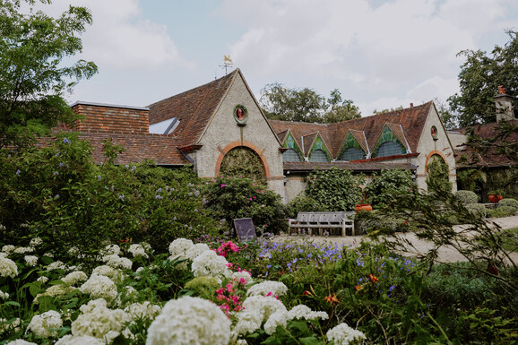 Exterior of Watts Gallery - Artists' Village with summer flowers in the foreground