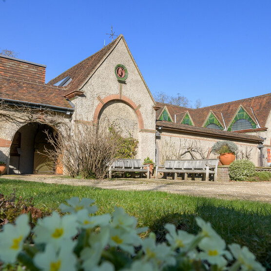 Outside of Watts Gallery building with flowers in foreground