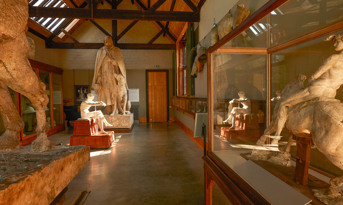 A wide angle shot of the Sculpture Gallery featuring various sculptures including a man riding a horse and a large statue of Alfred Lord Tennyson and his dog.