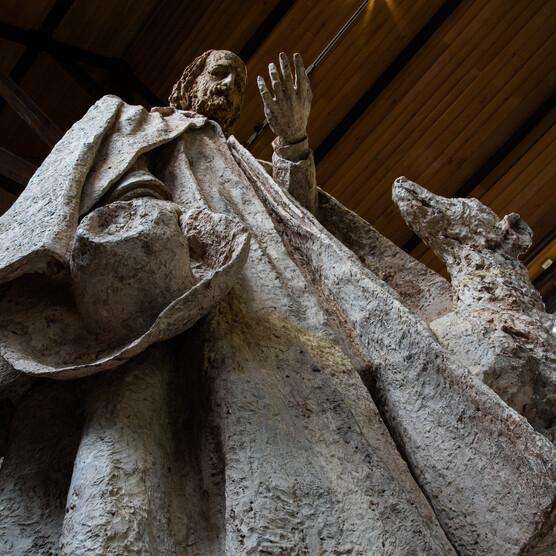 Looking up at a plaster model of Tennyson, featuring a man and his dog