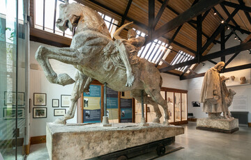 Large sculpture of a man riding a horse in gallery