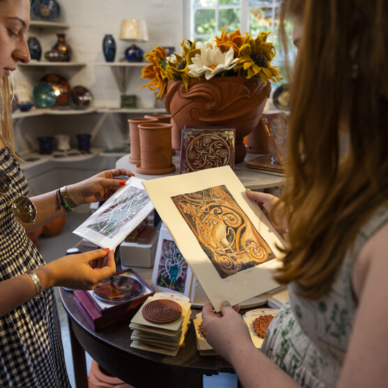 Two visitors browse prints in Shop