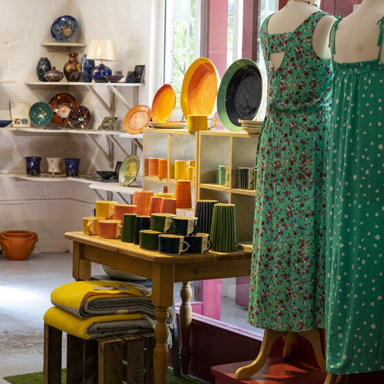 Ceramics on shelves and dresses on mannequins