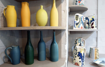 Brightly coloured vases on shelf in Shop
