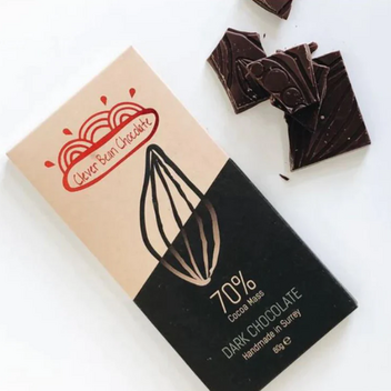 A bar of Clever Bean Chocolate in it packaging with some loose squares on a white background