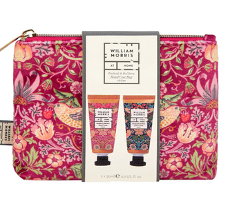 A wash bag with the famous William Morris print on in a pink colour with flowers, berries and birds. Inside the wash bag are two different scented hand creams.