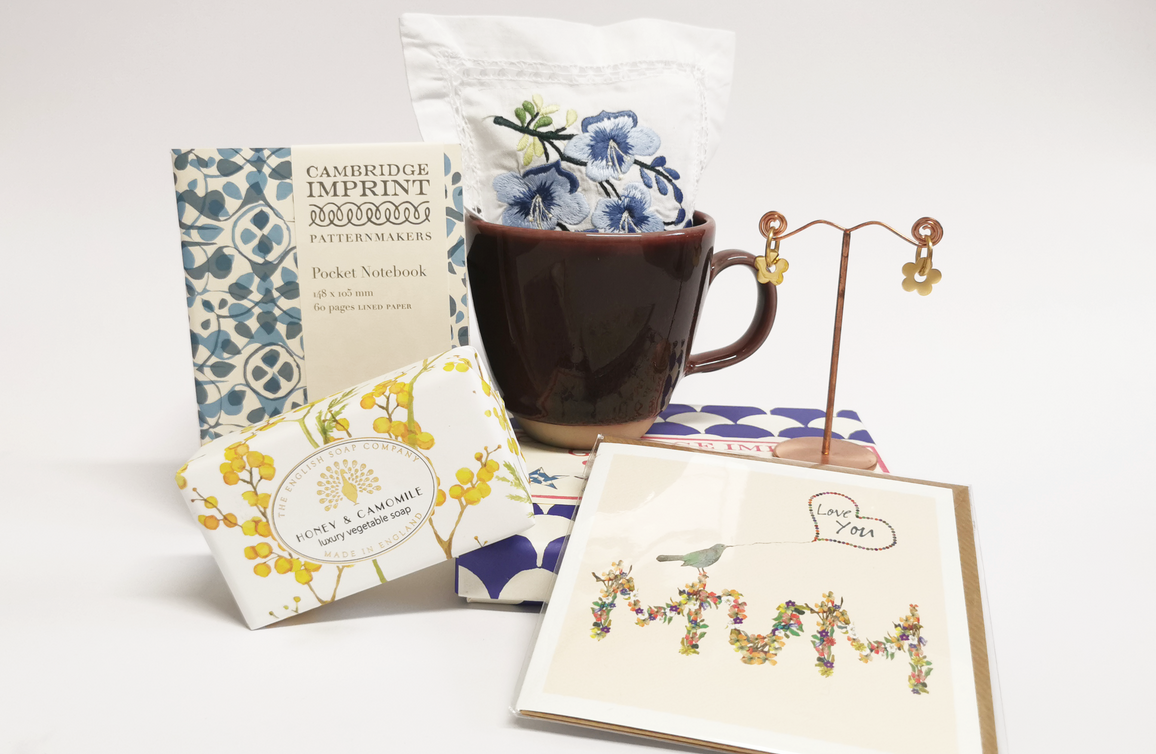 A range of different products from the Watts gift shop including cards, soap, earrings, mug and a notebook
