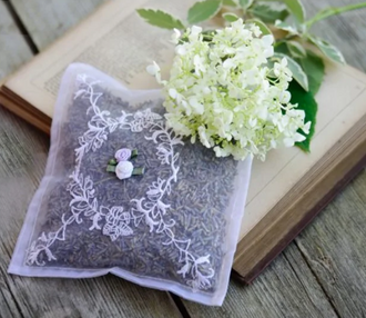 A sachet of lavender placed on a book with a flower