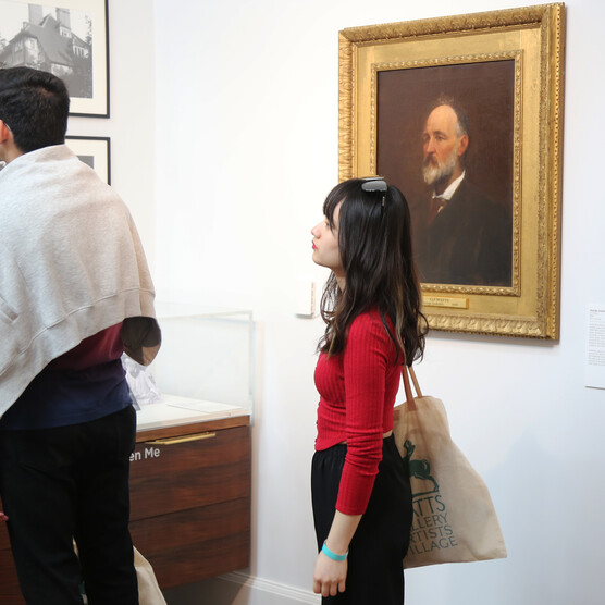 Two college students look at framed photographs in the Compton Studio