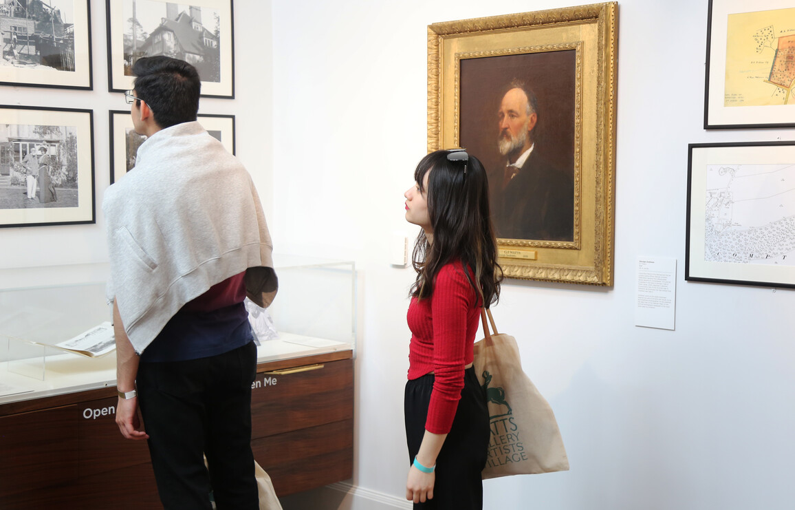 Two college students look at framed photographs in the Compton Studio