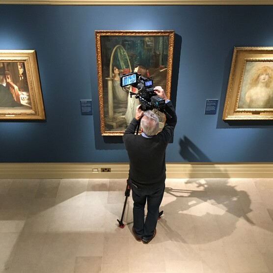 A man films a painting