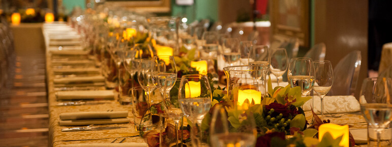 Table laid with glasses, foliage and candles